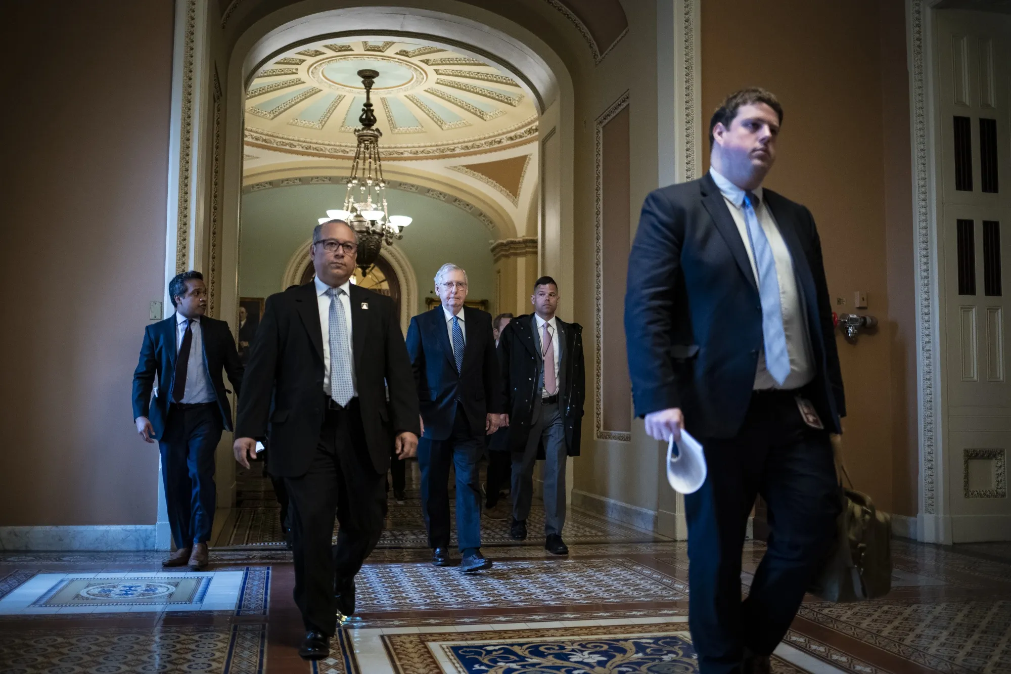 Mitch McConnell, center, walks to his office in the U.S. Capitol on March 23.