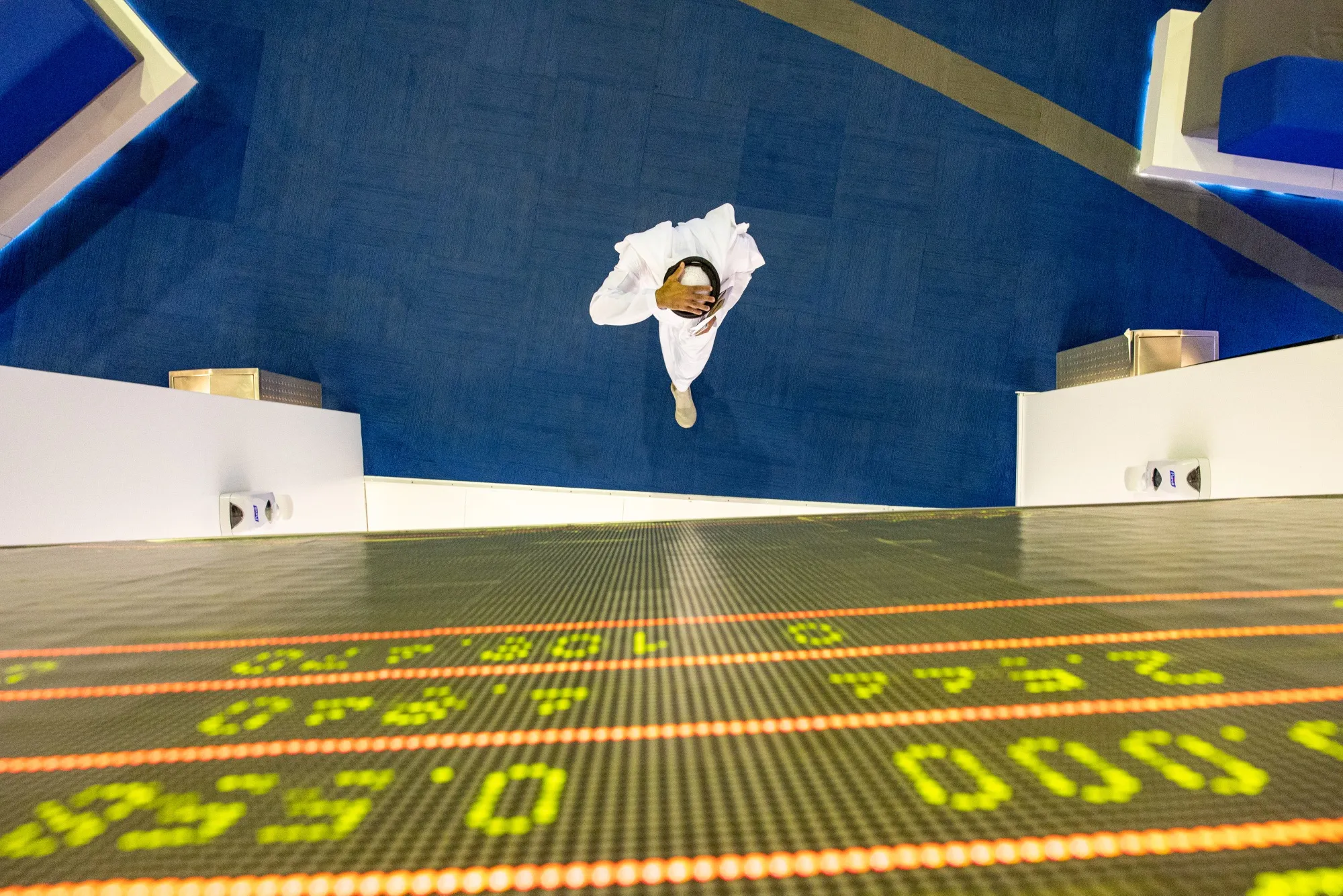 An investor walks past a stock price index board at the Dubai Financial Market.