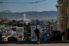A person rides an electric skateboard past homes in San Francisco, California, U.S., on Tuesday, Dec. 8, 2020. Declines in rent prices are steepening from earlier in the pandemic, a sign that people with the flexibility to move are leaving an area that's still among America’s priciest for housing.
