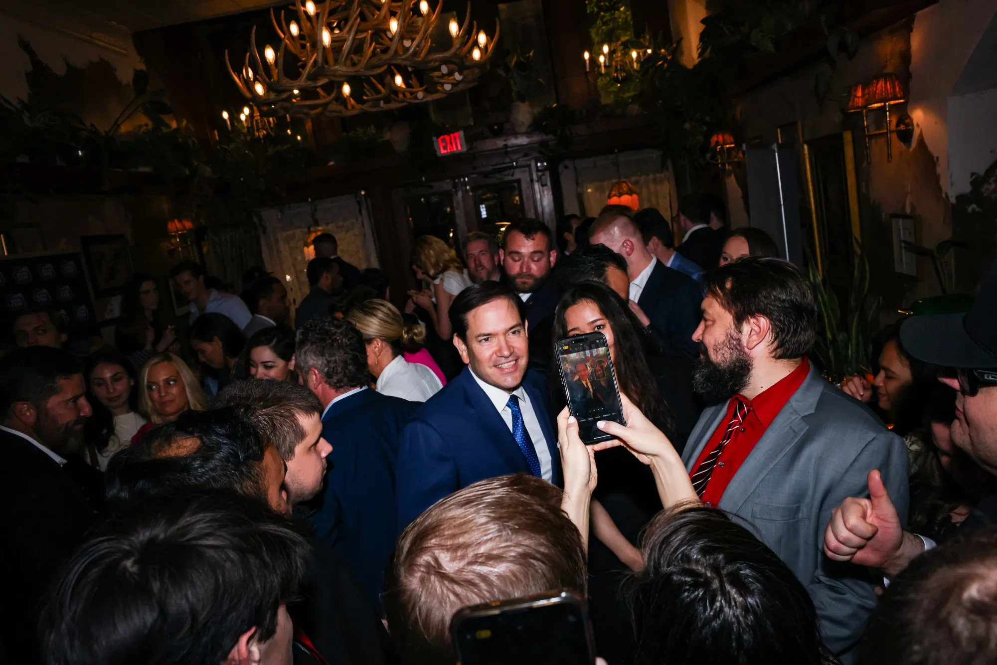 Secretary of State Marco Rubio takes photos with guests during a party at Butterworth's restaurant after the White House correspondents' dinner in Washington on April 26.