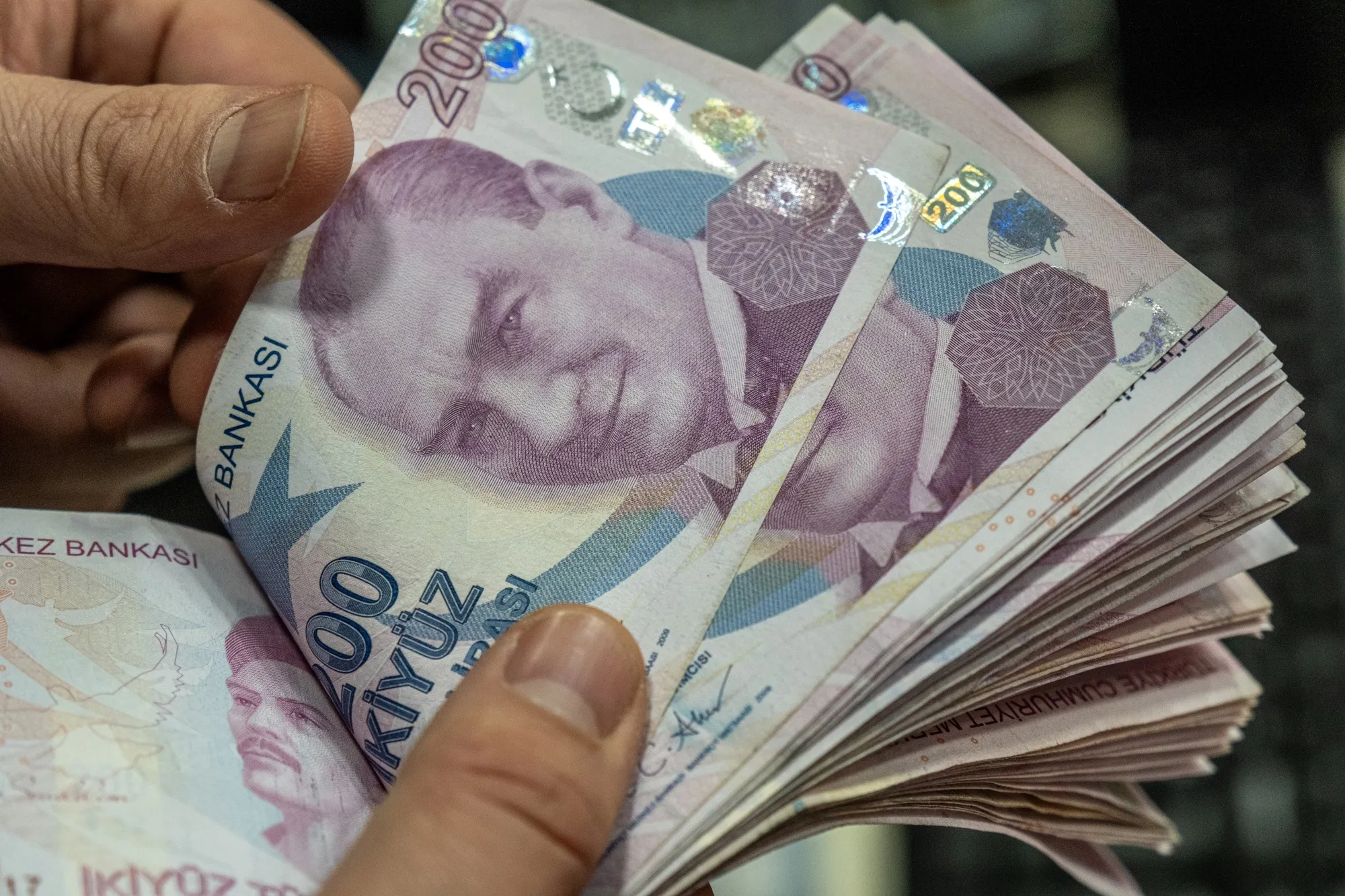 An employee counts 200 Turkish lira banknotes at a currency exchange bureau in Istanbul, Turkey, on Jan. 10, 2025.&nbsp;