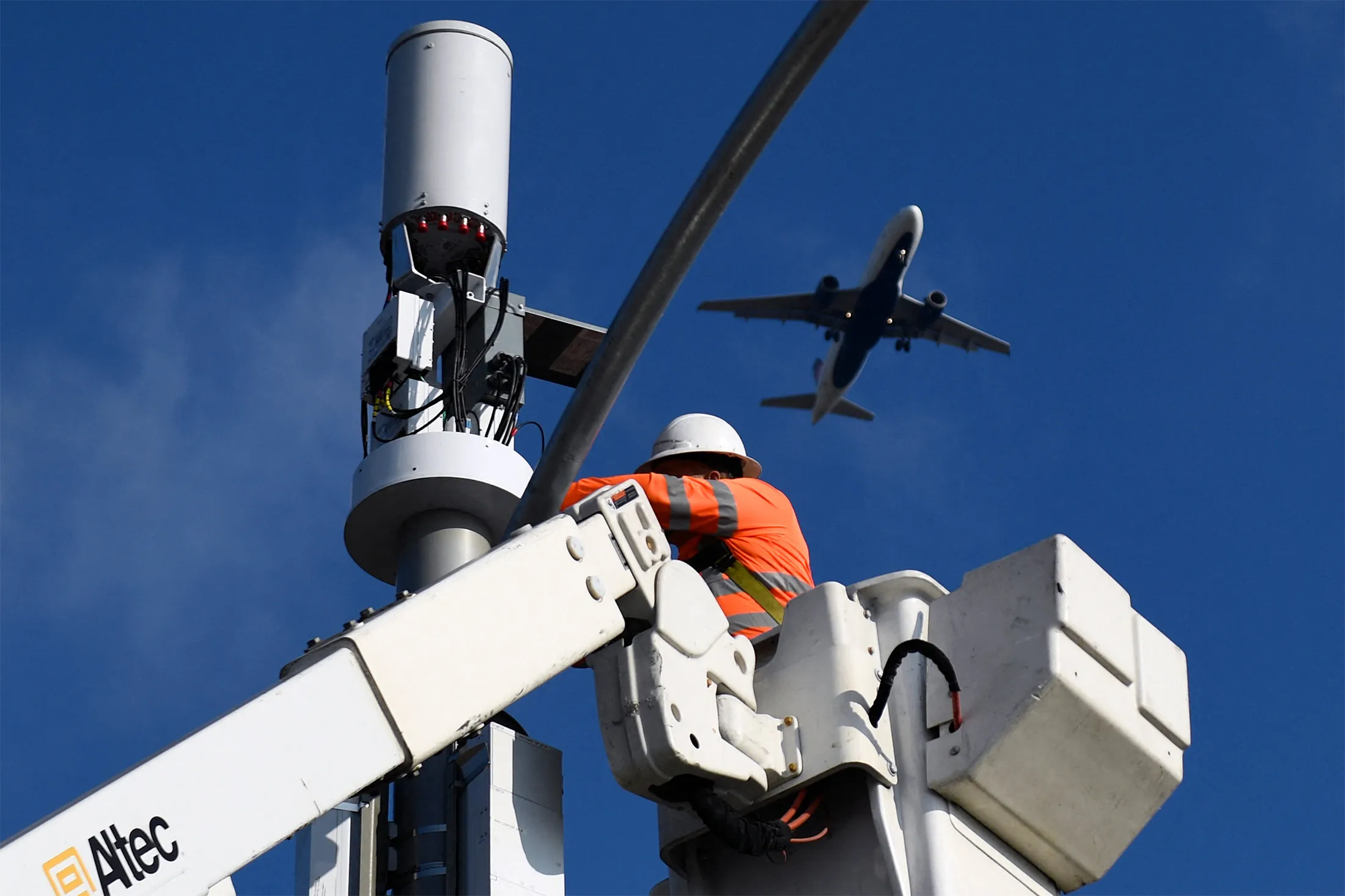 A contractor installs 5G equipment on a light pole near Los Angeles International Airport in California, on Jan. 19, 2022.&nbsp;