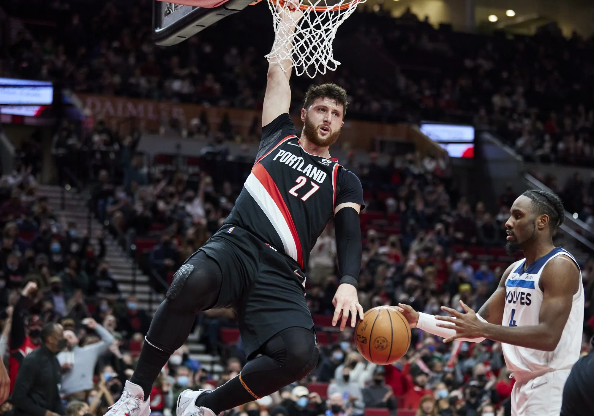 Portland Trail Blazers center Jusuf Nurkic, left, hangs on the rim after dunking in front of to Minnesota Timberwolves guard Jaylen Nowell during the first half of an NBA basketball game in Portland, Ore., Tuesday, Jan. 25, 2022. Nurkic agreed to a $70 million contract with Portland, Friday, July 1, 2022. (AP Photo/Craig Mitchelldyer, File)