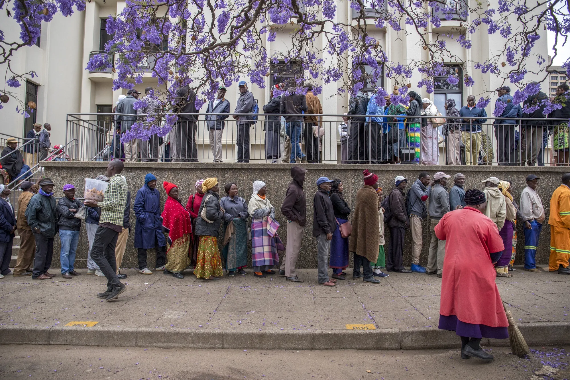 Pensioners queue to withdraw their pensions outside a branch of the Central African Building Society in Harare.