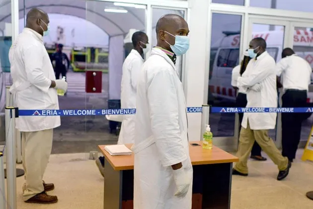 Medical staff wait for passengers arriving from Guinea at the airport in Abidjan on Oct. 20,as Ivory Coast's airline resumed flights to the three west African countries worst-hit by Ebola