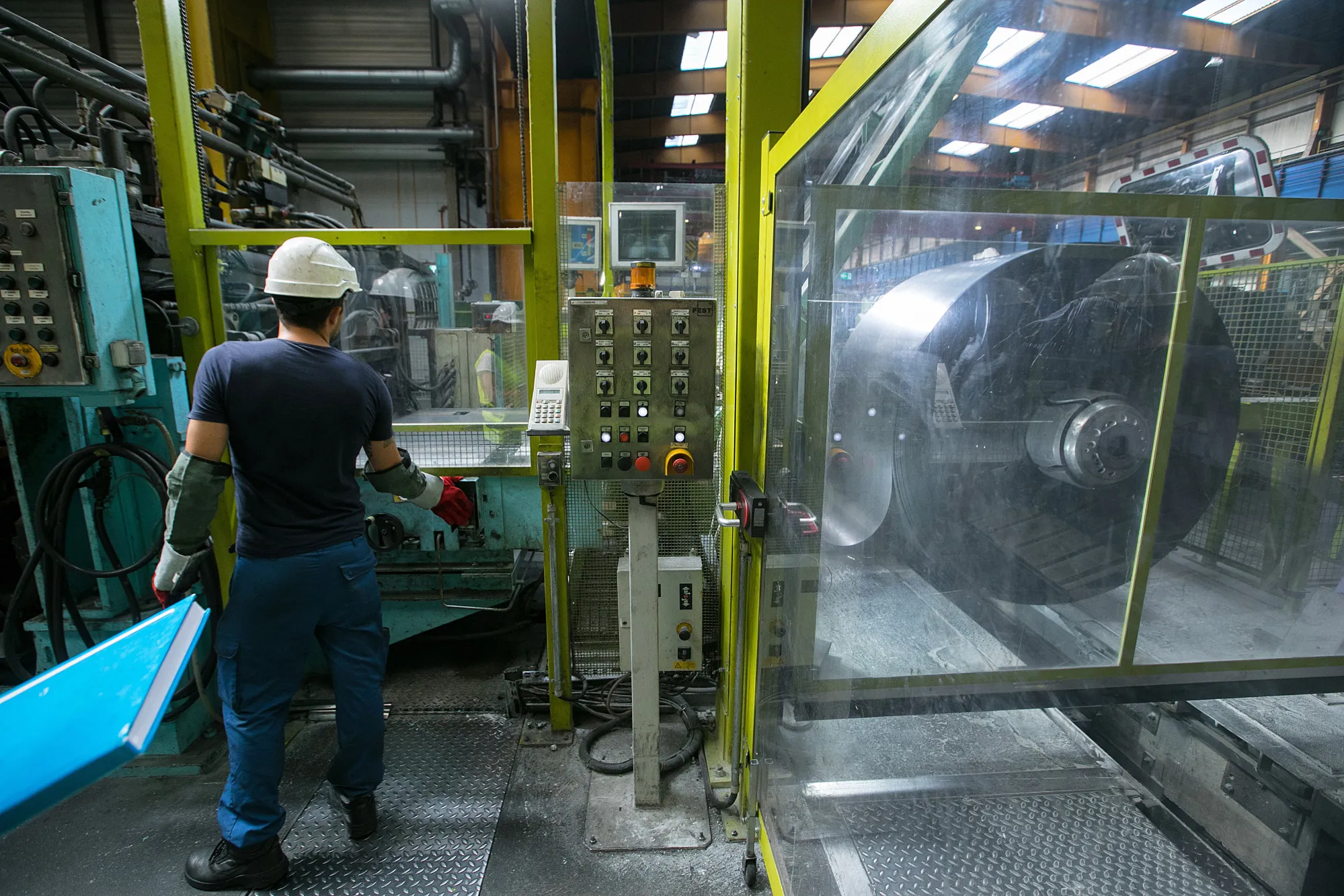 An employee loads a coil of strip steel for cleaning at the Thyssenkrupp Rasselstein GmbH steel packaging factory in Andernach, Germany.
