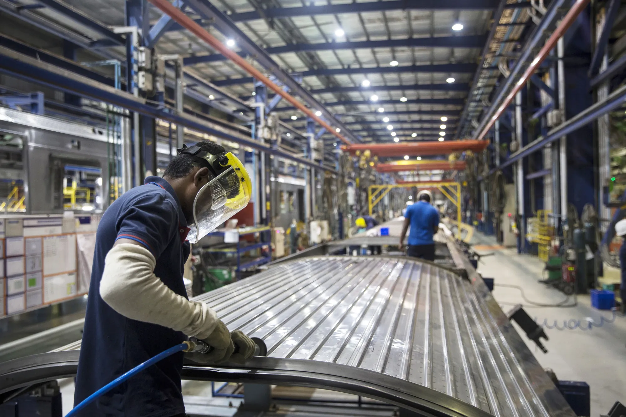A worker welds the chassis of a mass rapid transport (MRT) passenger car at the Alstom SA manufacturing facility in Sri City, Andhra Pradesh, India.