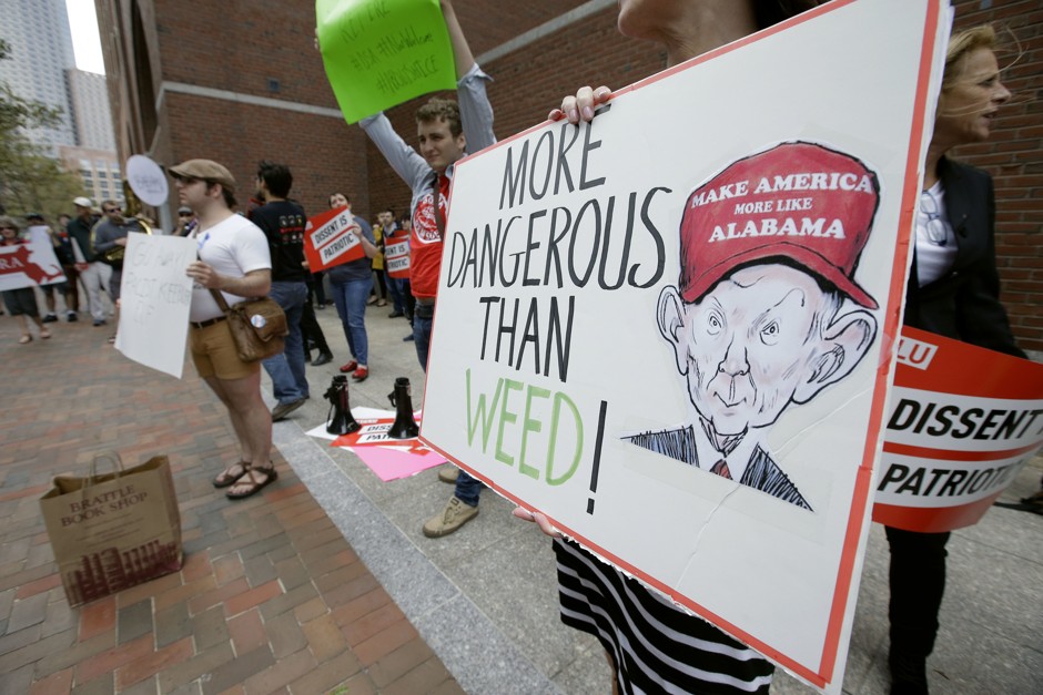 Jean Inglis holds a sign depicting U.S. Attorney General Jeff Sessions as she protests outside the federal courthouse in Boston where Sessions was speaking. 