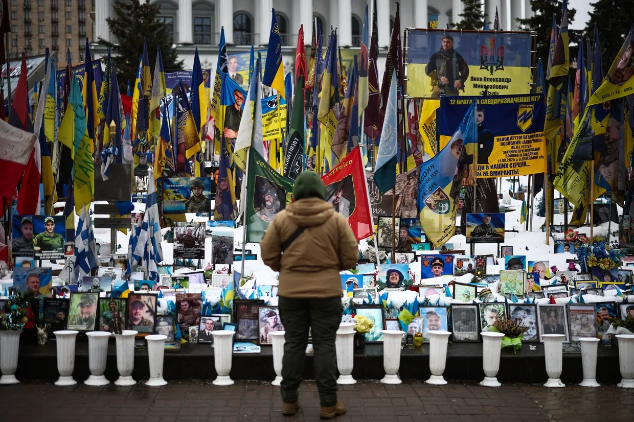 A person stands at a makeshift memorial to fallen Ukrainian and foreign soldiers in Independence Square in Kyiv on Feb. 23.&nbsp;