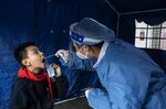 A medical worker tests a child for Covid-19 in Wuhan on Nov. 18.