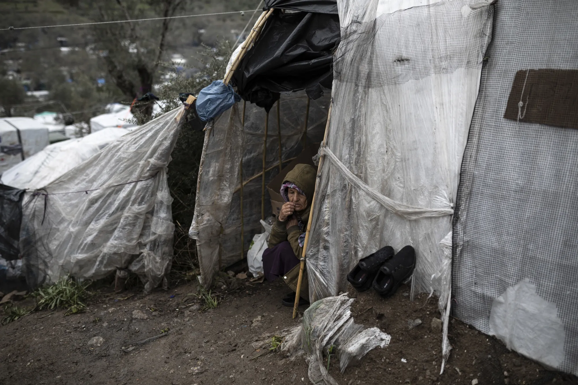 An elderly woman sits at the entrance of her tent at the temporary refugee camp on the island of Lesbos, Greece, on March 5.