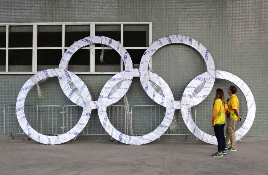 Workers inspect a set of Olympic Rings scheduled to be installed inside Olympic Park in Rio de Janeiro on July 30, 2016.