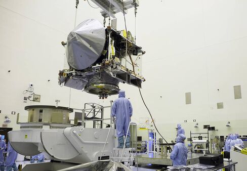 The OSIRIS-REx spacecraft is hoisted for positioning at NASA's Kennedy Space Center in Florida.