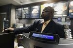 A plain-clothed police officer mans a position behind the counter at the Starbucks that has become the center of protests in Philadelphia.