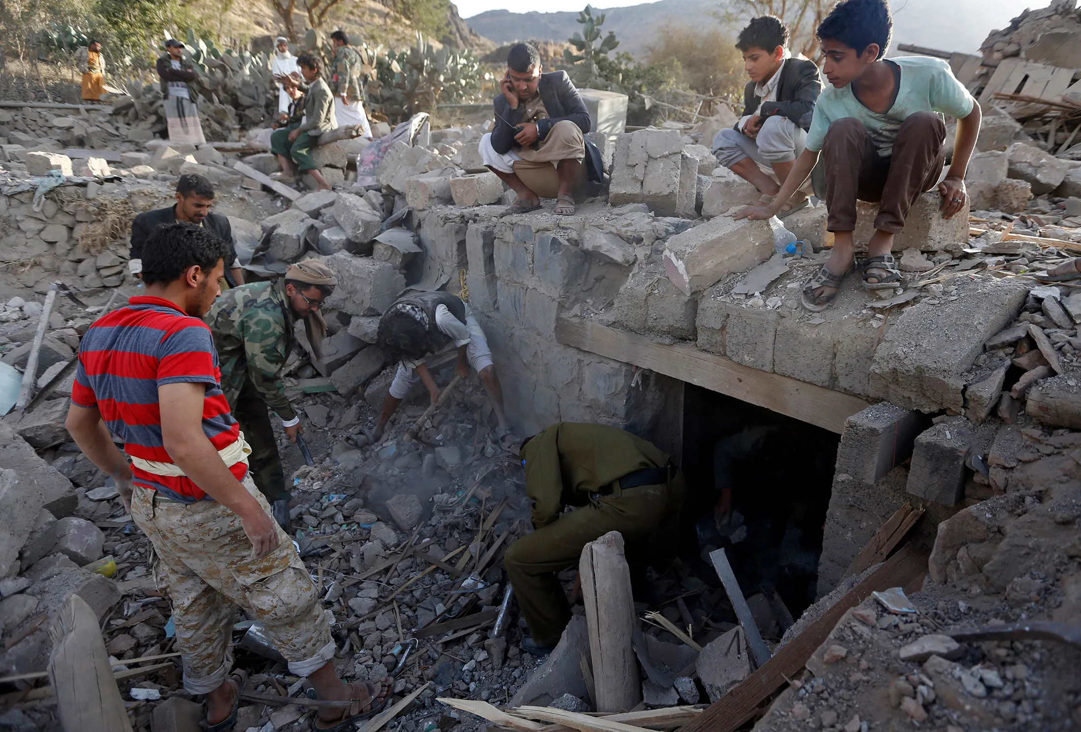 Yemenis search under the rubble of damaged houses following reported Saudi-led coalition air strikes on the outskirts of the Yemeni capital Sanaa on Feb. 1, 2017.

