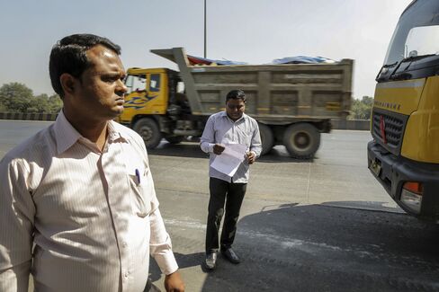Manoj Zhope, an anti-encroachment officer, right, and Ajit Tandel, sanitary officer from Flying Squad, monitor papers of incoming debris trucks from Mumbai at Vashi in Navi Mumbai, India.
