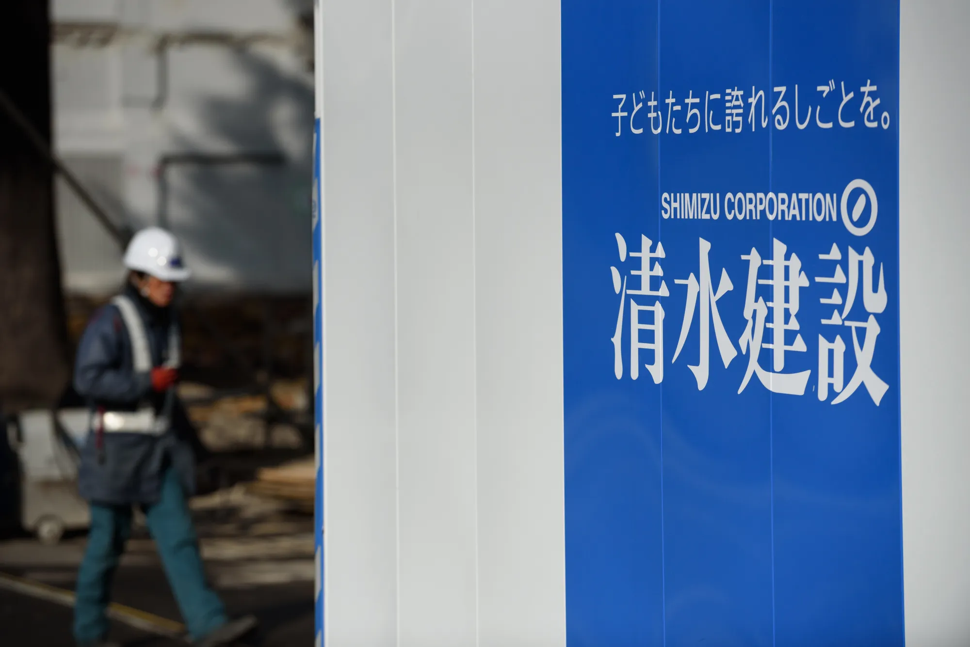 A logo of Shimizu Corp. is displayed on a fence at a construction site in Tokyo, Japan.