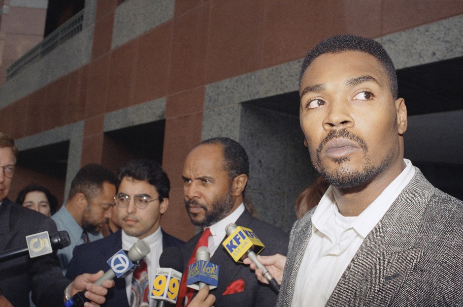 Rodney King, right, and his lawyer Milton Grimes, chat with reporters after leaving the federal courthouse in Los Angeles on March 22, 1994.
