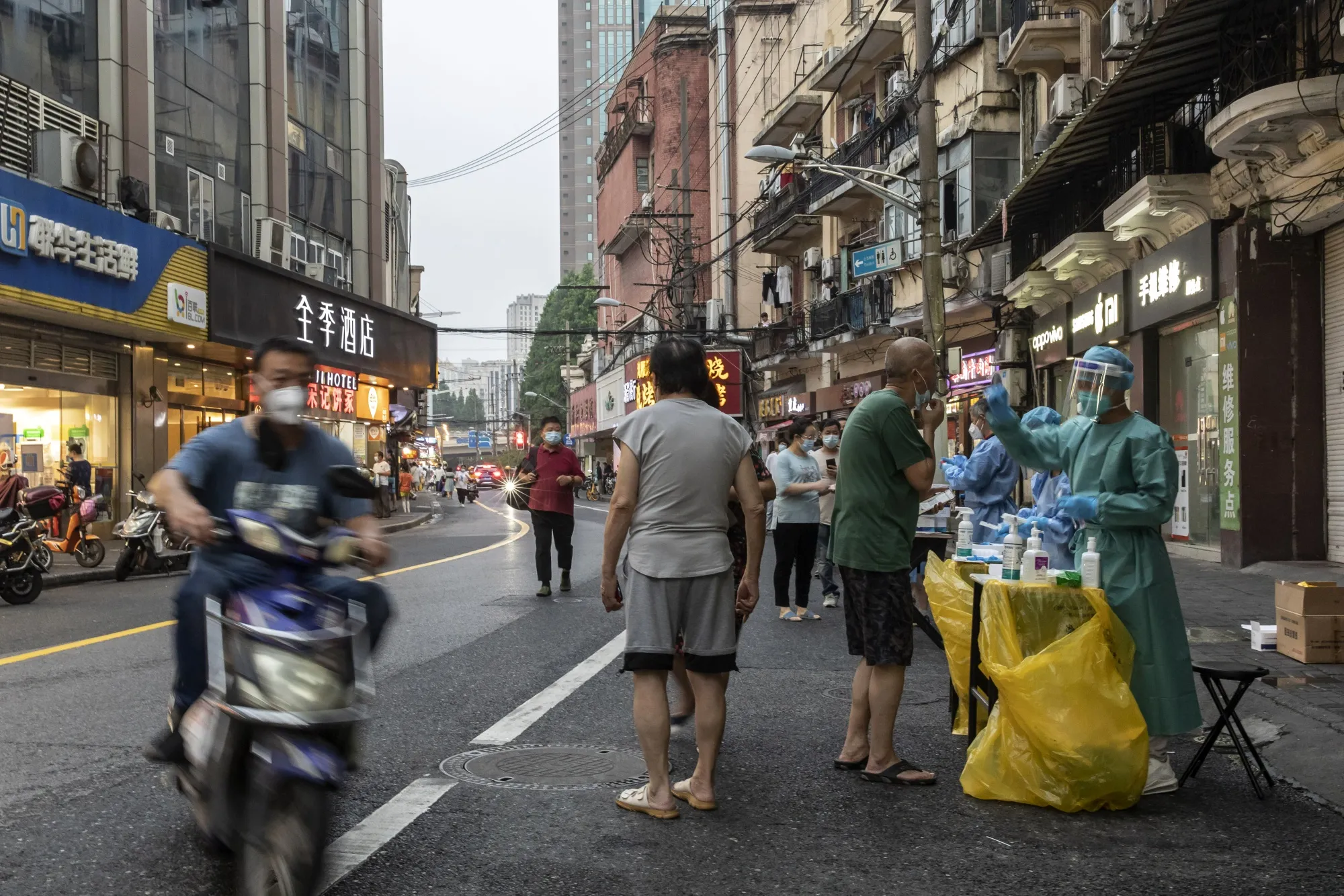 Healthcare workers in protective gear assist residents taking Covid-19 tests in Shanghai on July 19.