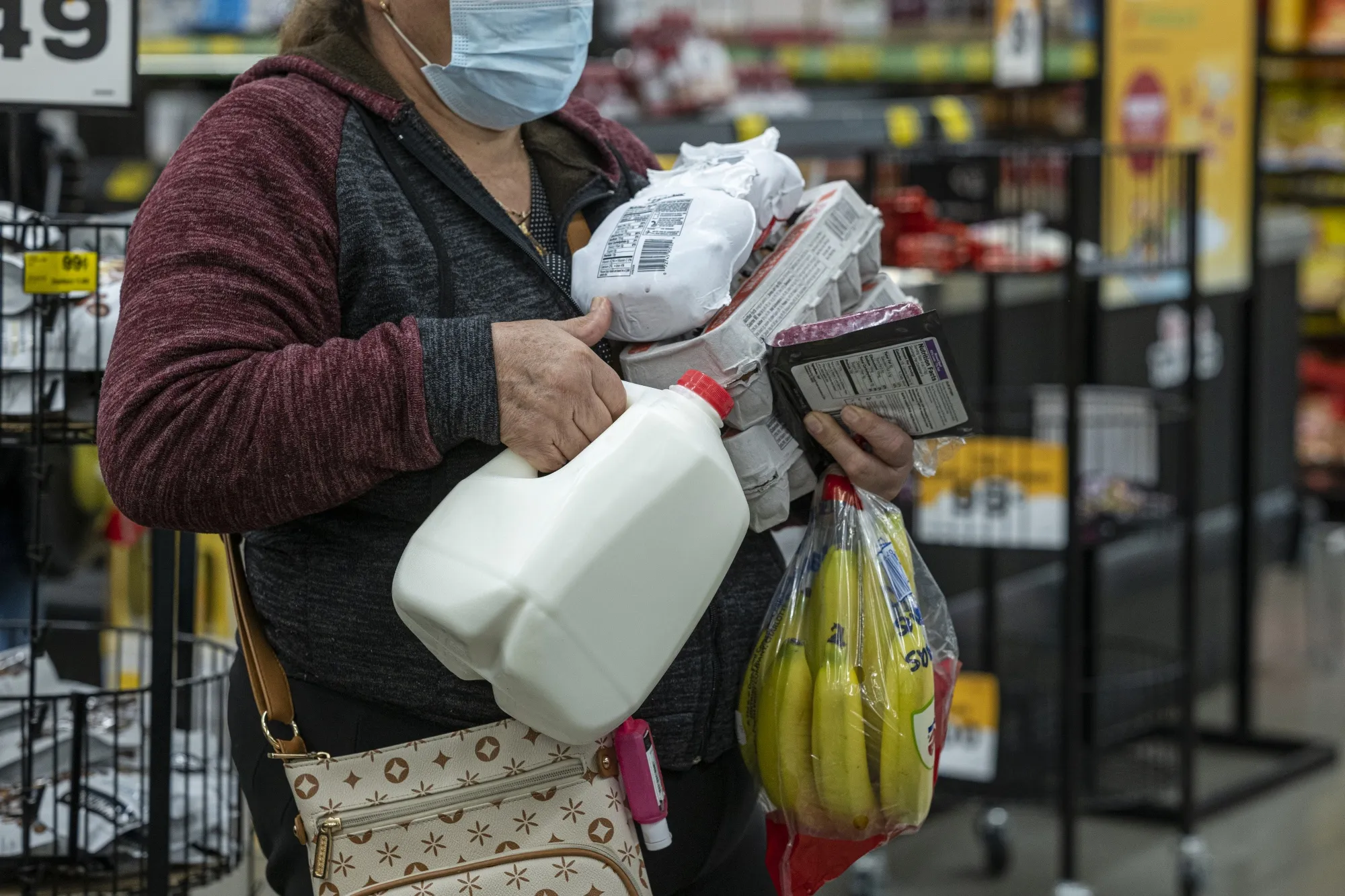 A shopper holds groceries while waiting to checkout inside a grocery store in San Francisco, California.