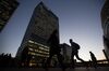 Commuters walk past the JP Morgan building in the Canary Wharf business, financial and shopping district of London, U.K., on Wednesday, Oct. 28, 2015.