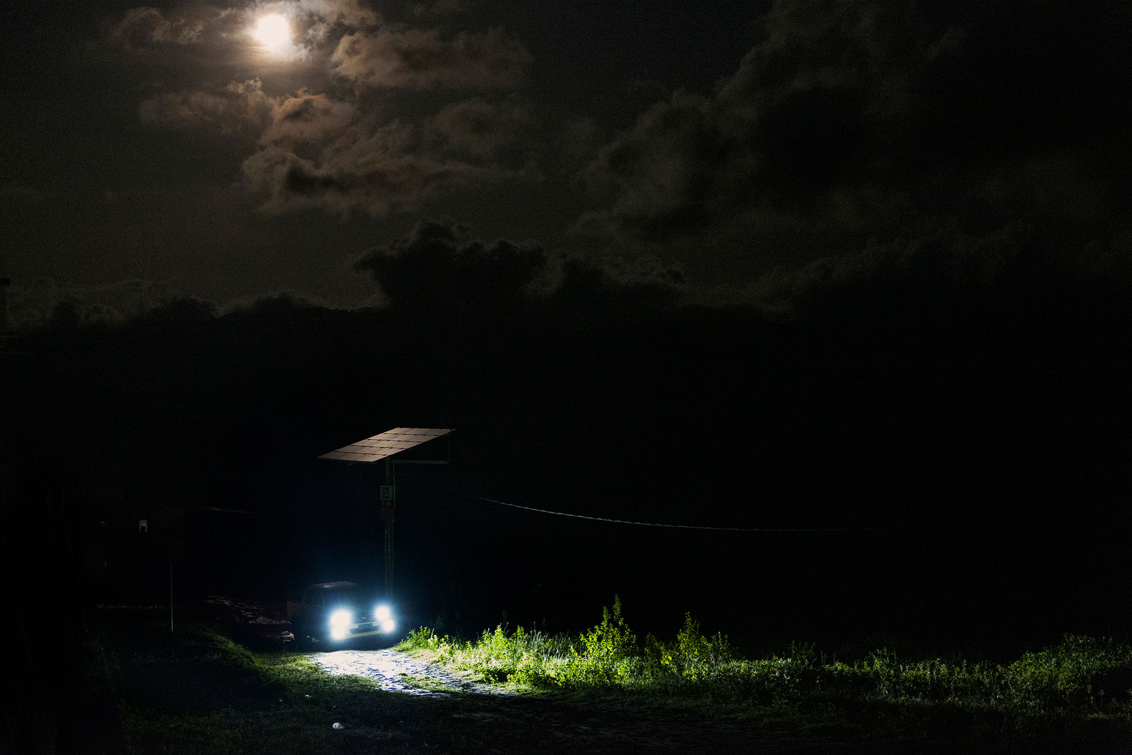 A car passes a solar panel at night