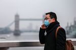 A commuter, wearing a protective face mask, crosses London Bridge in view of Tower Bridge in London, U.K., on Thursday, March 19, 2020.