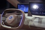 The steering wheel and digital dashboard of a BMW iNext concept electric sport utility vehicle.