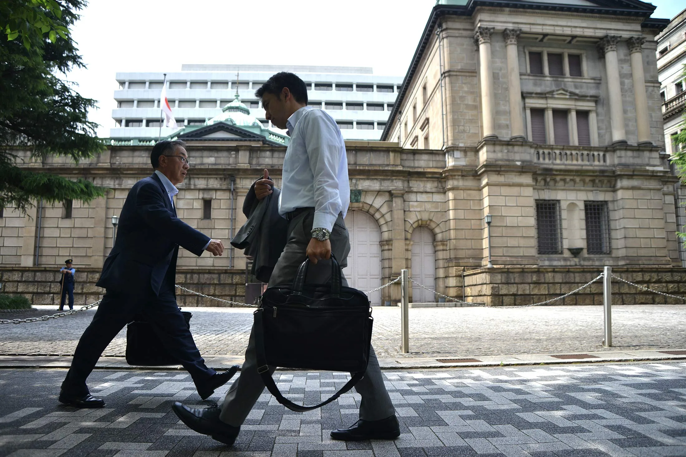 Businessmen walk past the Bank of Japan in Tokyo, Japan, June 08, 2016.
