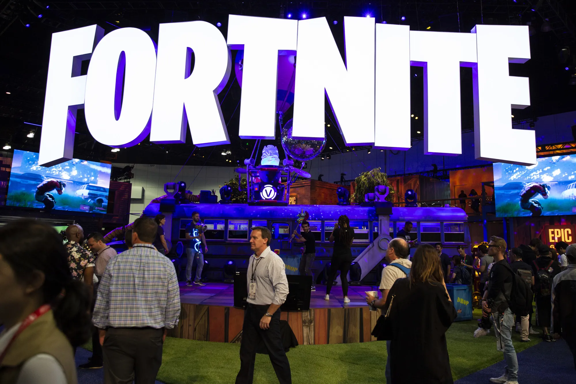 Attendees walk past the Epic Games Inc. Fortnite: Battle Royal booth during the E3 Electronic Entertainment Expo in Los Angeles.