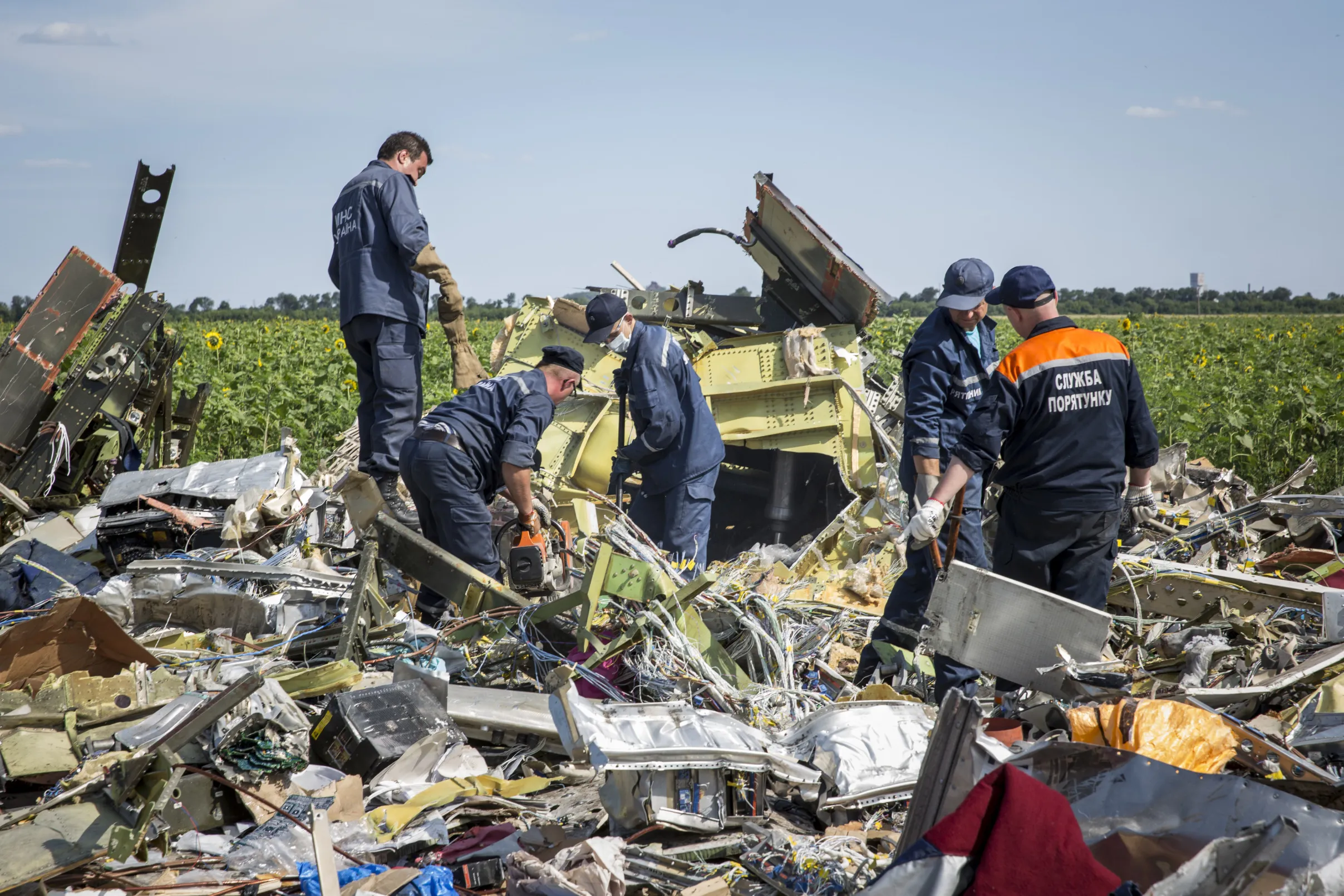 Ukrainian rescue servicemen inspect part of the wreckage of Malaysia Airlines flight MH17 on July 20, 2014 in Ukraine.&nbsp;