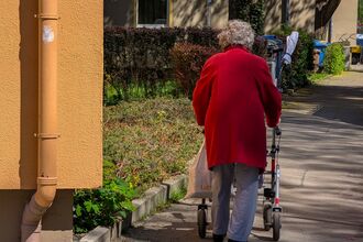 Senior Woman With Rollator And Shopping Bag
