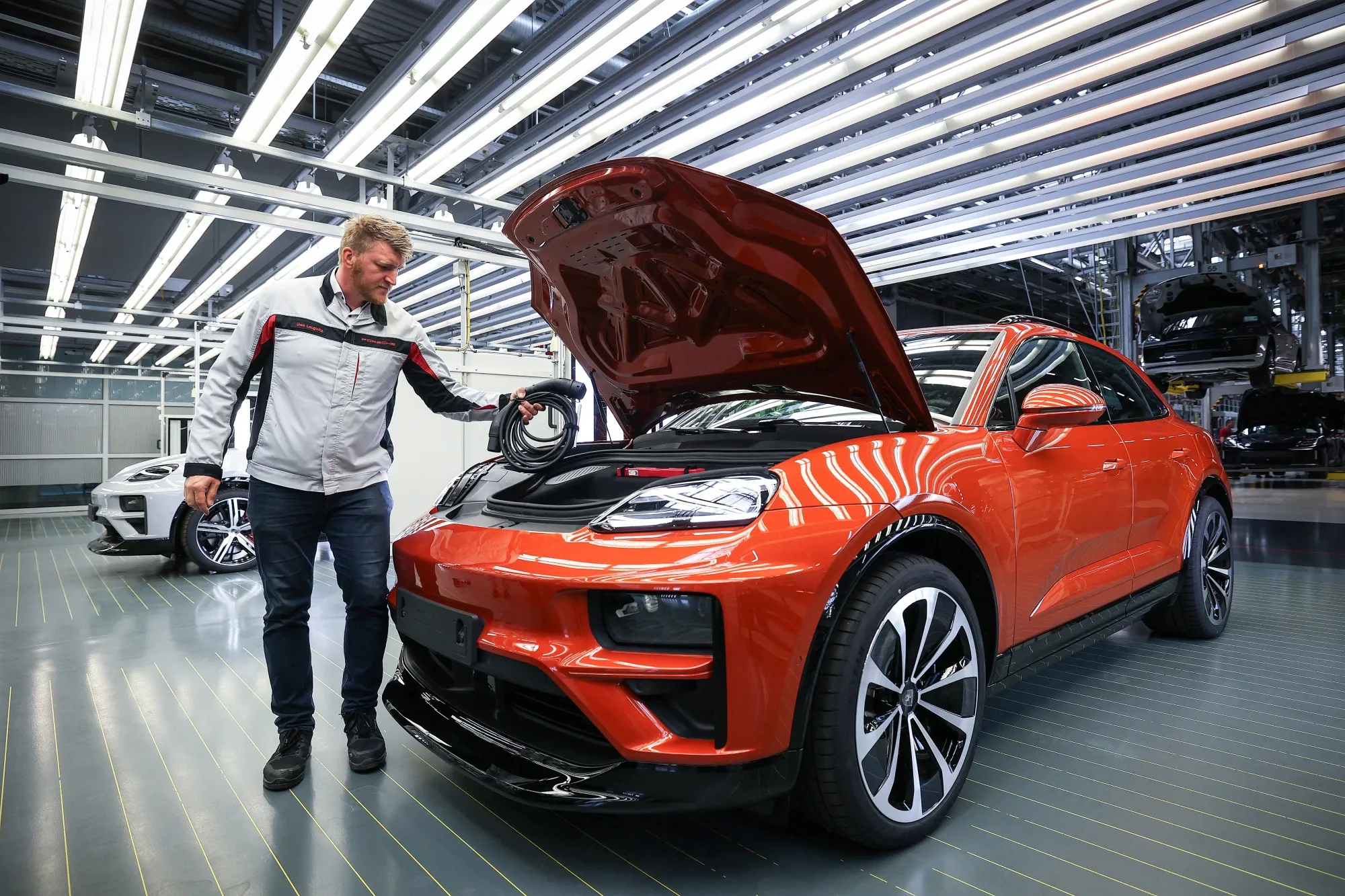 A Porsche&nbsp;employee inspecting a new Macan 4 Electric sport utility vehicle in Leipzig, Germany.