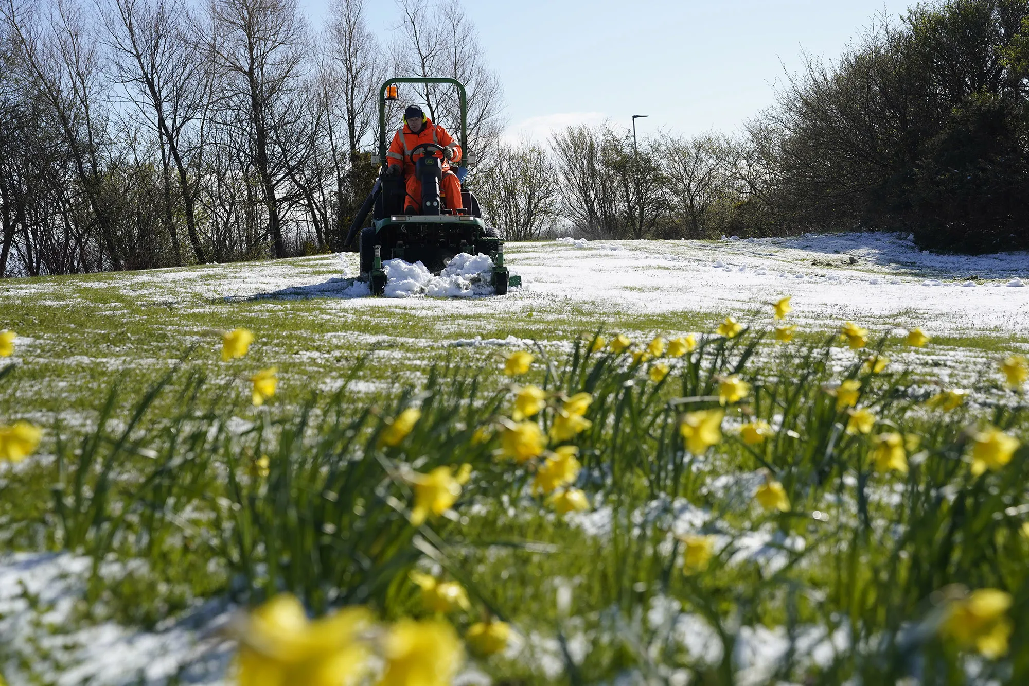 A worker mows a lawn that has been dusted with snow in Beamish, Durham, England&nbsp;following a cold&nbsp;weekend&nbsp;on April 12.