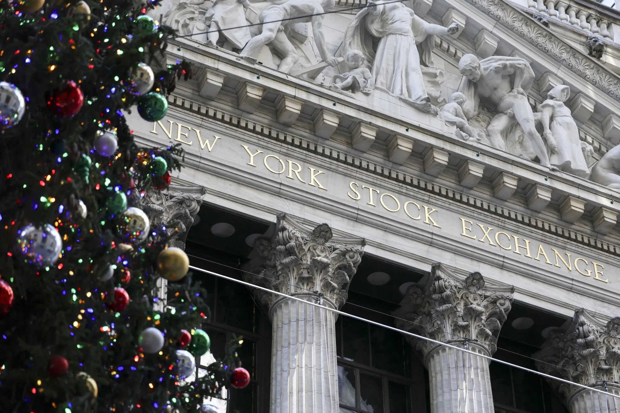 クリスマスツリーとニューヨーク証券取引所（2025年12月5日、Photo by ANGELA WEISS / AFP via Getty Images)