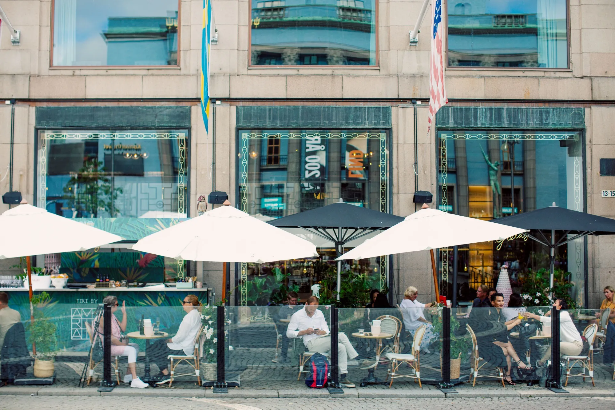 Customers sit at the terraced tables of a cafe in Stockholm on Aug. 6.