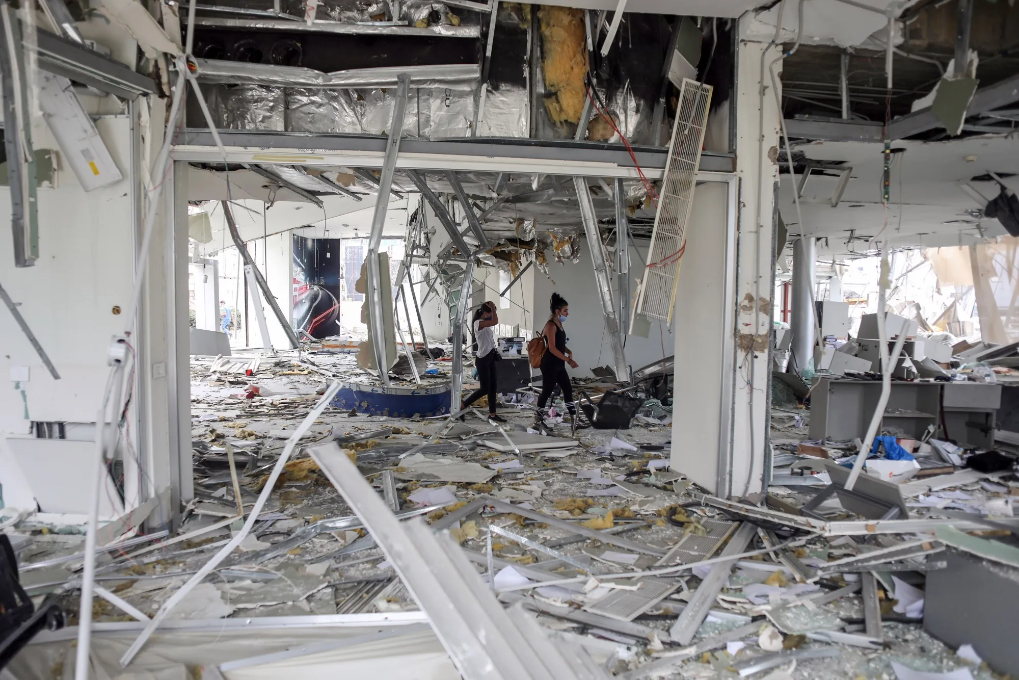 People inspect damage inside a car dealership in Beirut on Aug. 7.