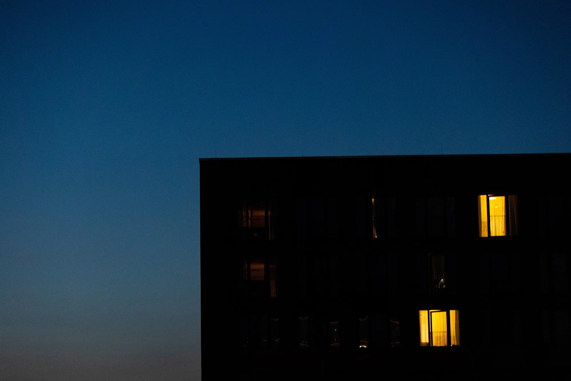 A partially lit block of apartments at dusk in Berlin, Germany.&nbsp;