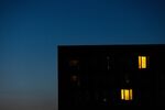 A partially lit block of apartments at dusk in Berlin, Germany. 