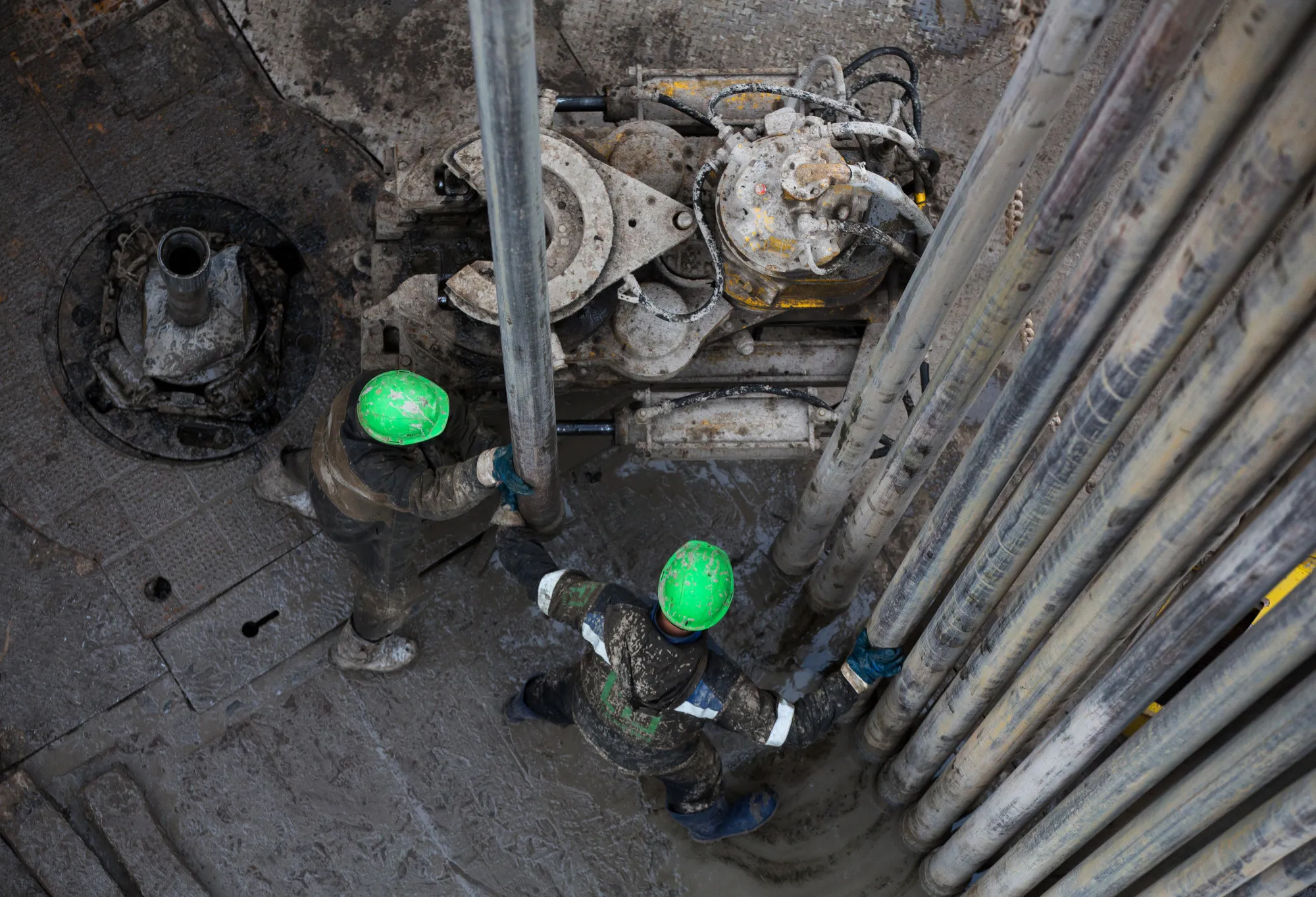 Workers position drill bits on a drill rig during oil drilling operations&nbsp;near Ufa, Russia.