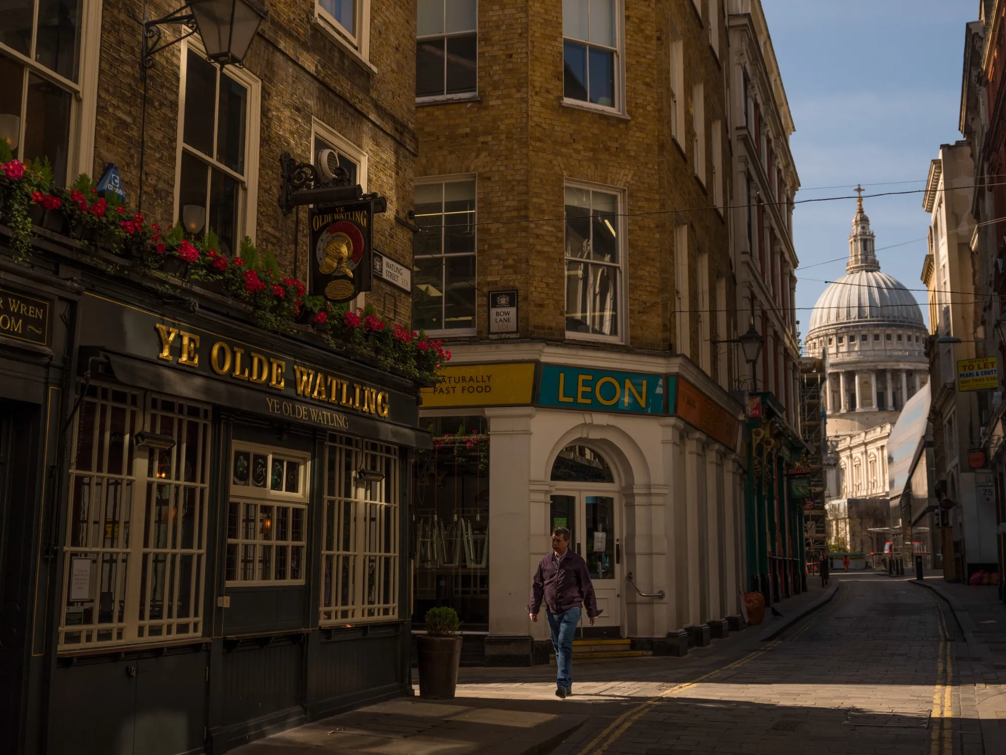 A pedestrian walks past closed cafes and a pub in view of St. Paul's Cathedral in London, U.K., on&nbsp;March 24.