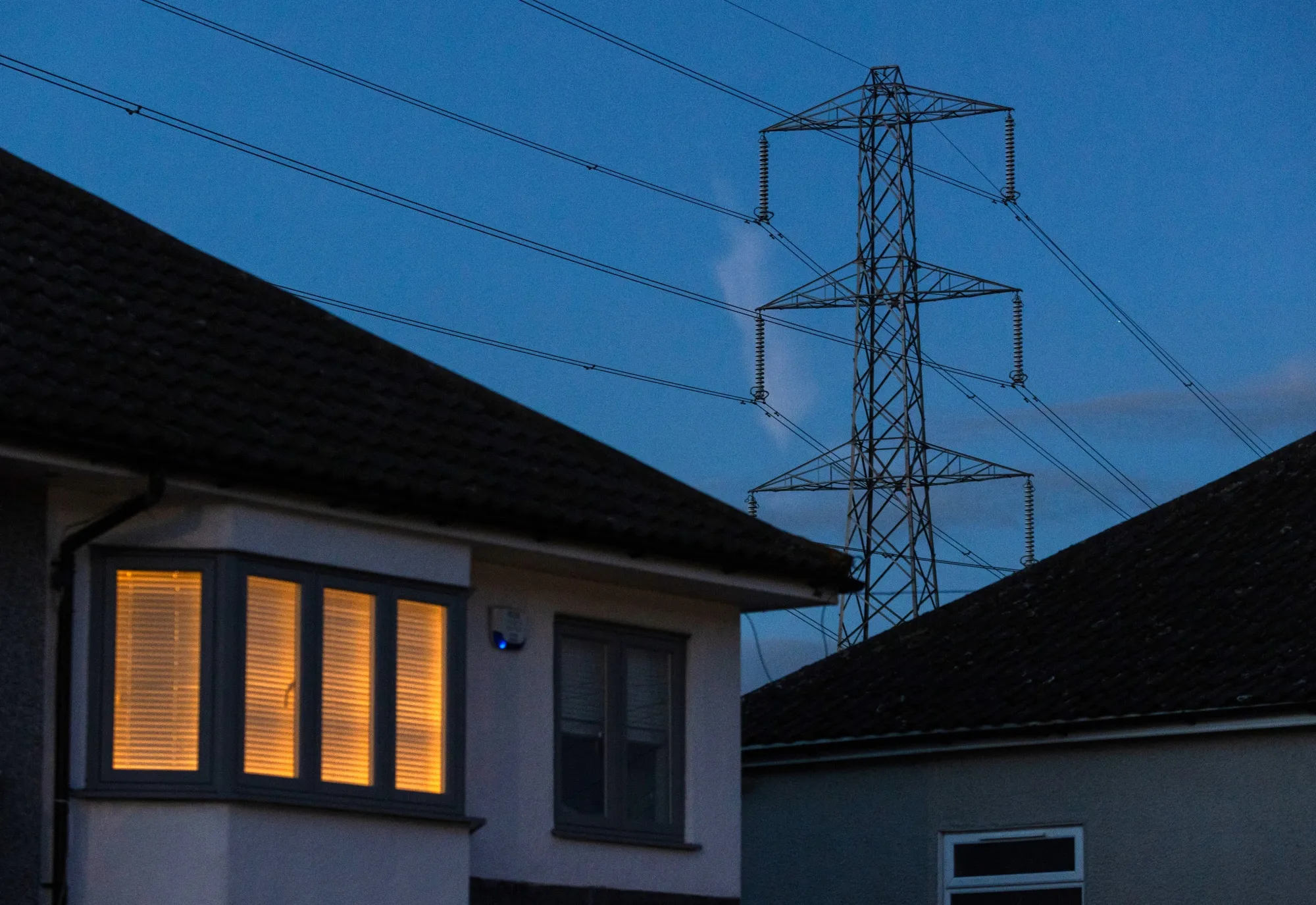 A light on at a residential home near an electricity transmission tower in Upminster, UK, on July 4.