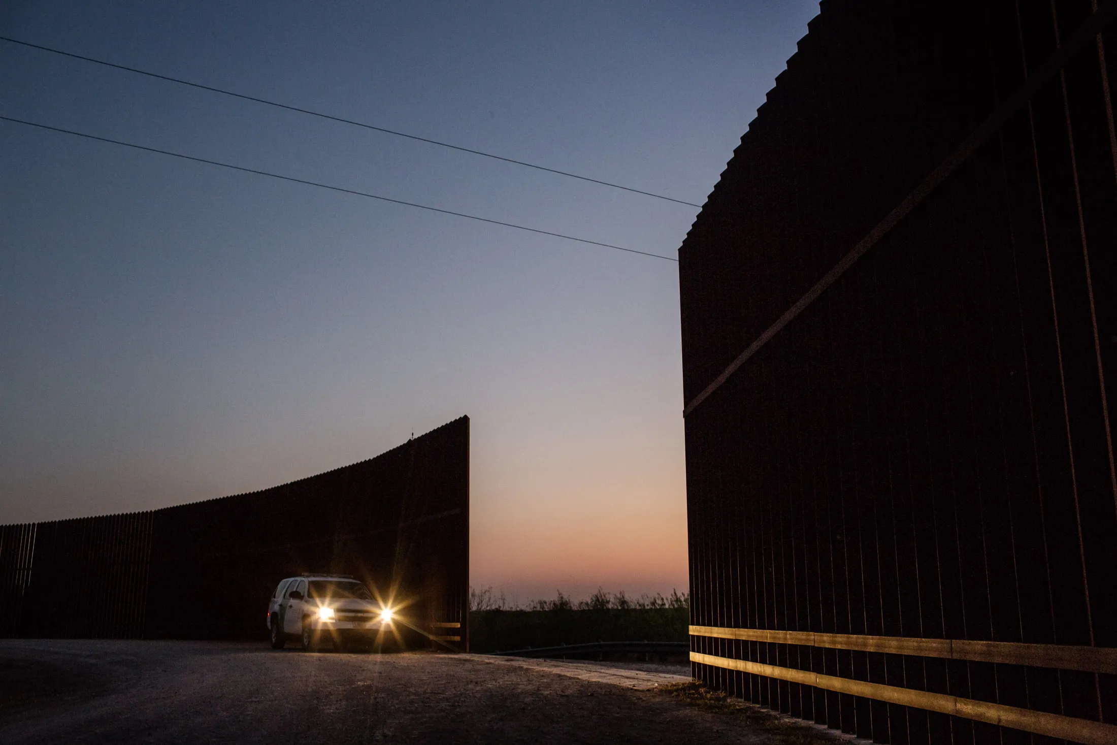 A U.S. Customs and Border Protection agent stationed outside a break in the fence on private farmland in Peñitas. Only some of these gaps, which occur about every quarter mile, are regularly manned.
