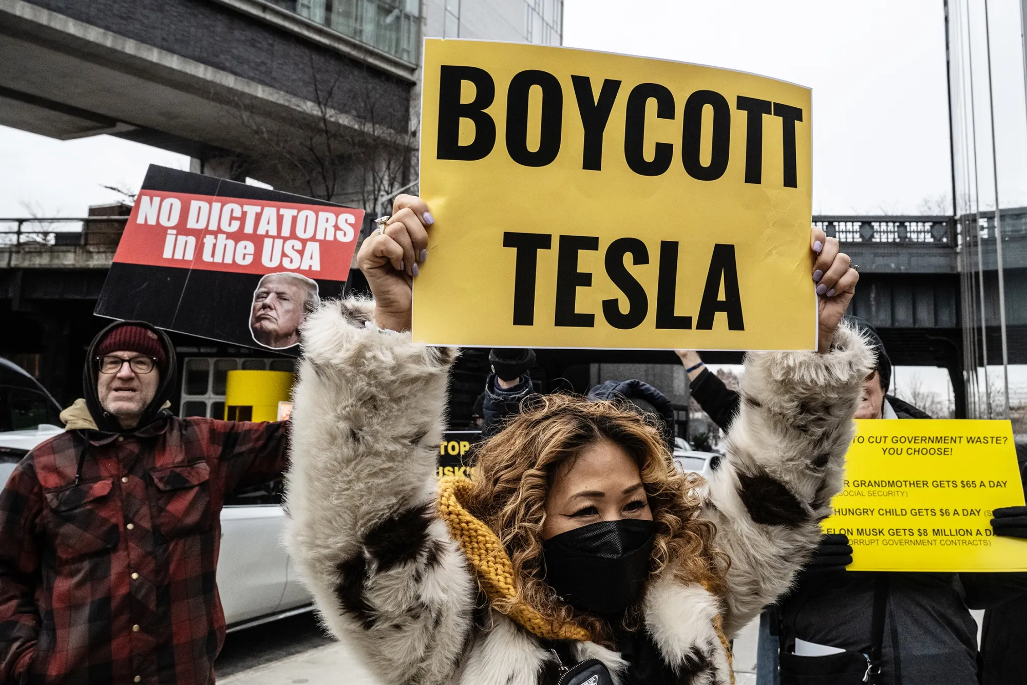 Protesters rally against Elon Musk’s actions at a Tesla showroom in New York.