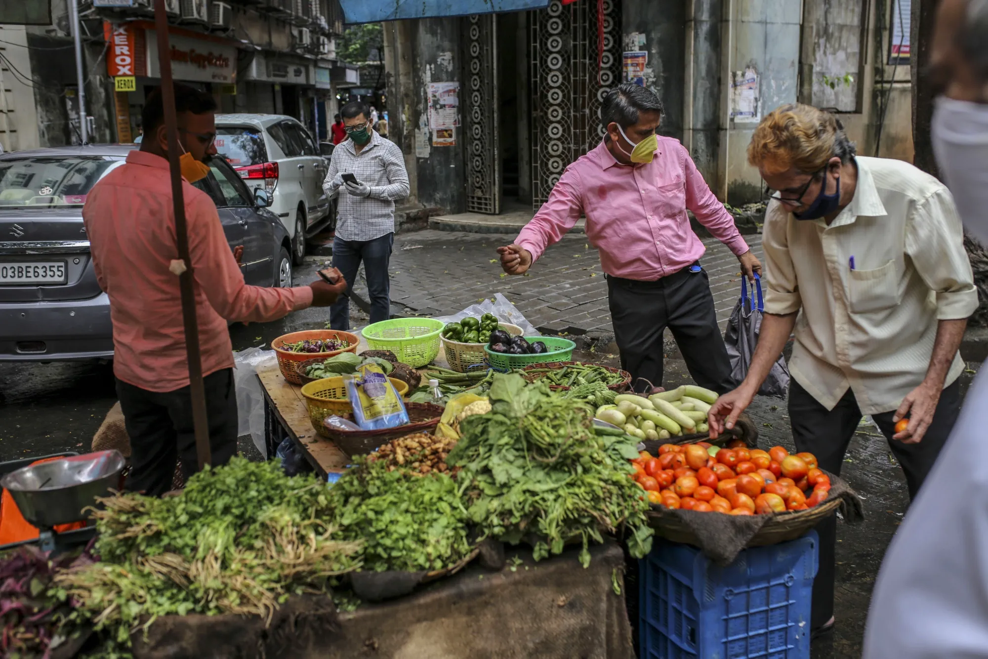 Shoppers wear protective masks while buying vegetables from a street stall in Mumbai.