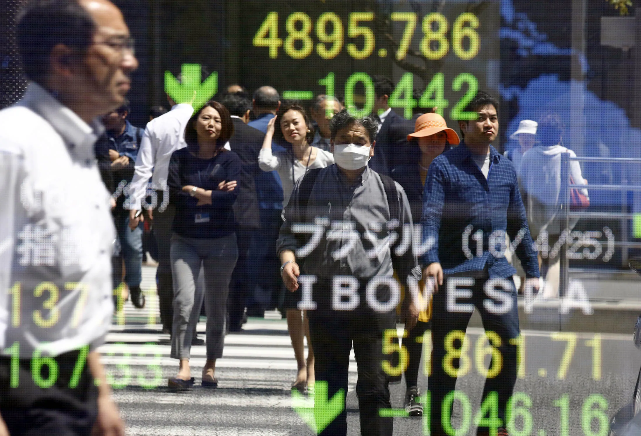 People are reflected on the electronic board of a securities firm in Tokyo.
