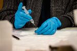 A healthcare worker prepares syringes filled with the Pfizer-BioNTech Covid-19 vaccine at the University of New Mexico's Gallup campus in Gallup, New Mexico, U.S., on Tuesday, March 23, 2021.