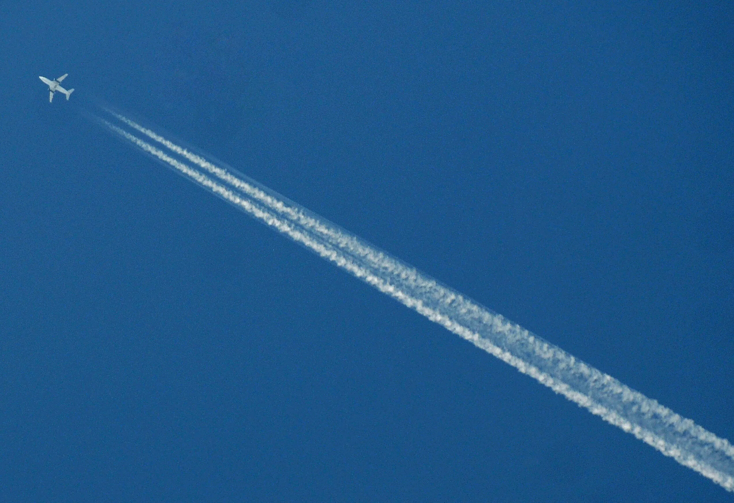 A passenger airplane leaves a trail thro