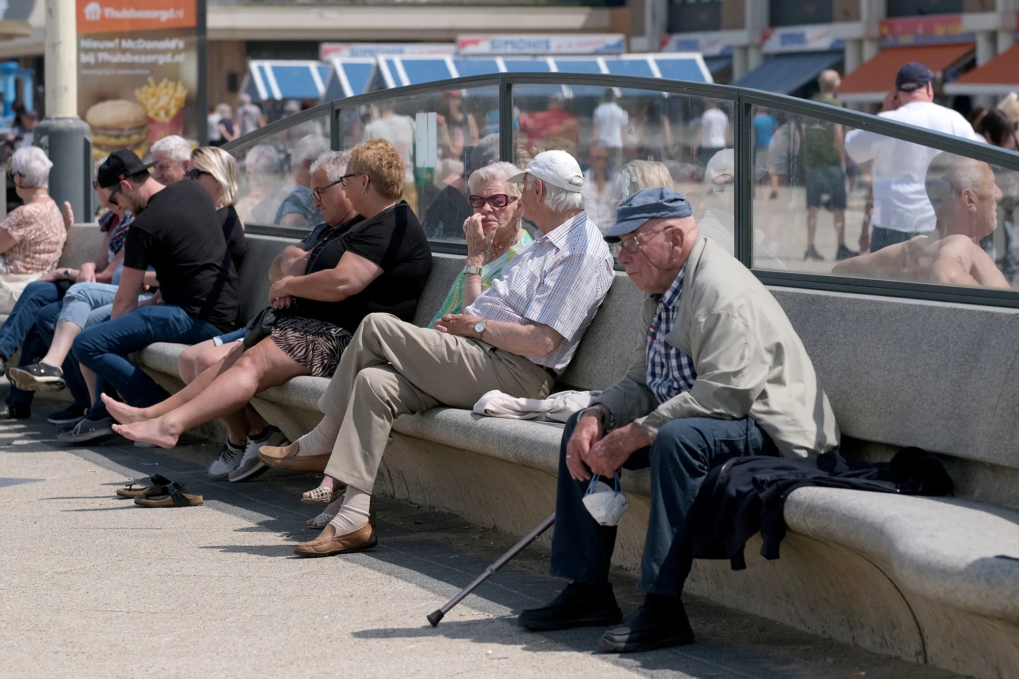 Elderly people sit on a bench at Scheveningen beach in The Hague, Netherlands.