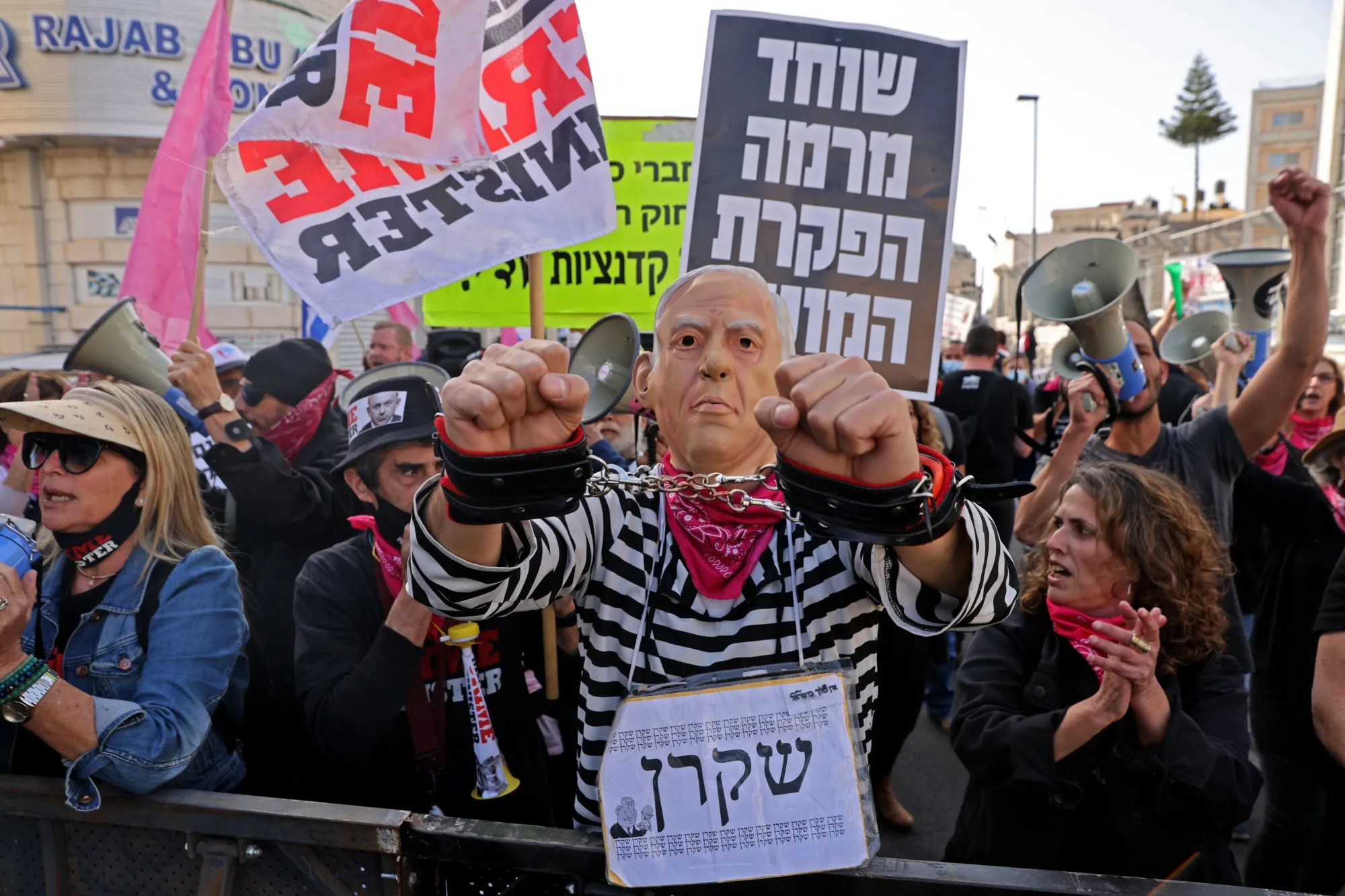 A protester wearing a mask, depicting Israeli Prime Minister Benjamin Netanyahu, attends a gathering outside the district court in Jerusalem, April 5.